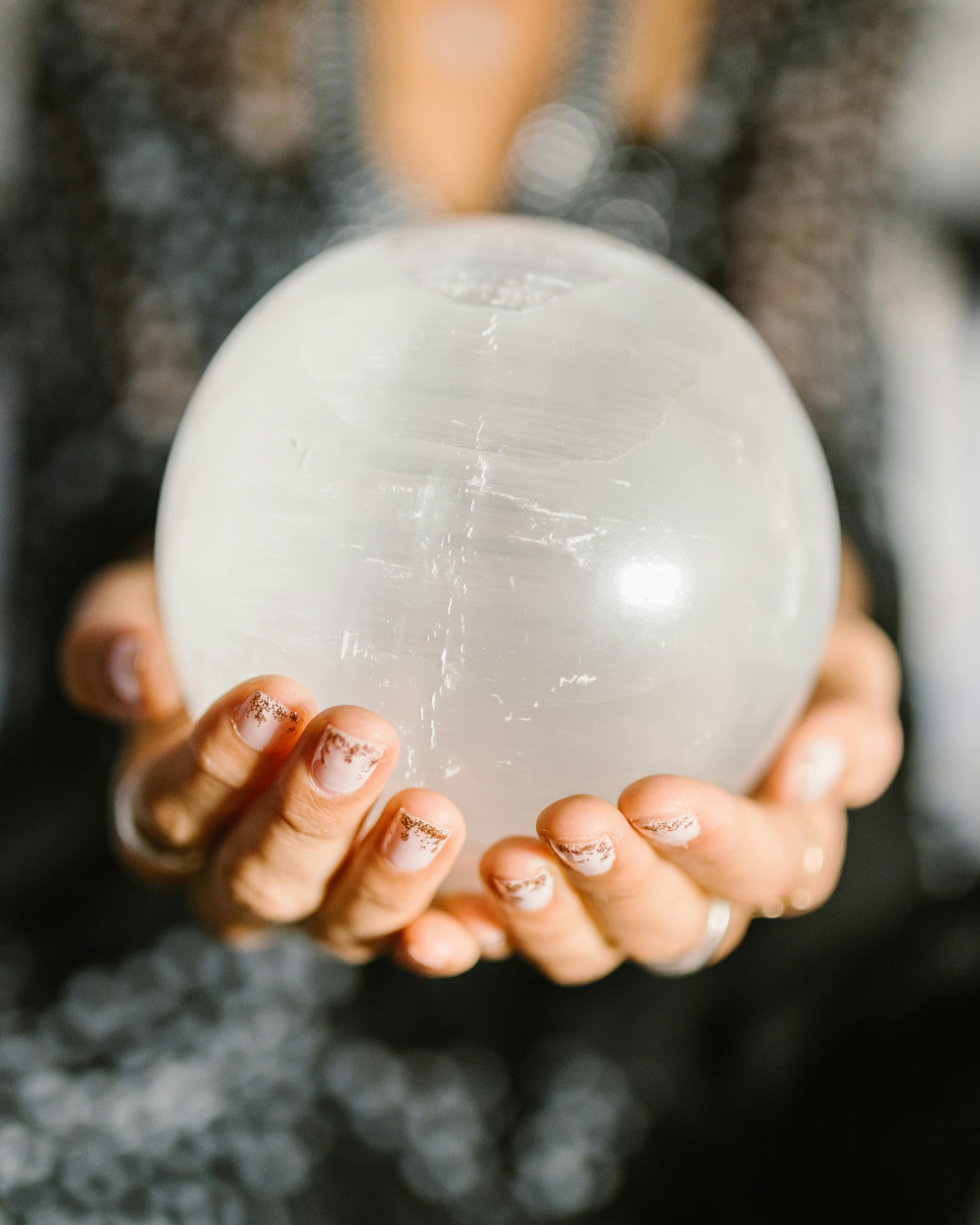 Outstretched hands holding a crystal ball.